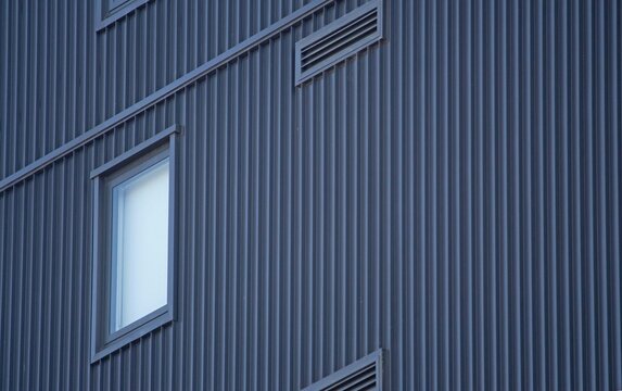 Close up of corrugated metal clad structure with window and vents