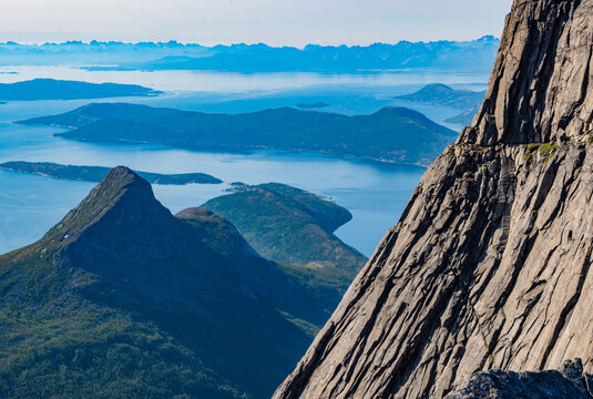 High steep rock walls on the Stetinden peak in North Norway with hikers and climbers trying to reach the summit