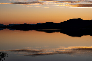 Obraz premium Orange and yellow evening lights on a beach in Northern Norway during the midnight sun