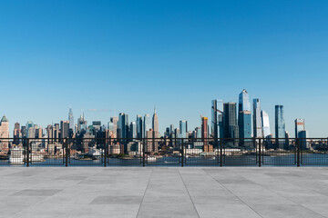 Obraz premium City skyline with skyscrapers and clear blue sky viewed from a rooftop terrace.