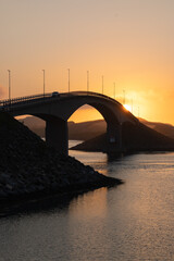 Midnight sun over a bridge in the Lofoten islands, Northern Norway with amazing orange light behind...