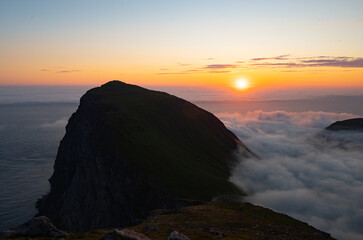 Sea of clouds at dramatic colorful evening sky during the midnight sun in the Lofoten, Northern...