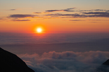 Sea of clouds at dramatic colorful evening sky during the midnight sun in the Lofoten, Northern Norway