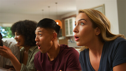 Friends Reacting With Surprise During an Exciting Game Night at Home in the Evening