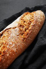 Fresh bread on a black napkin on a dark background