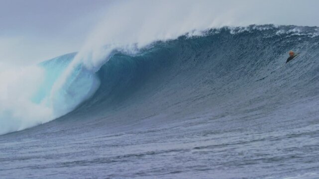 Thick heavy ocean wave from Cloudbreak Fiji crashes with whitewash spraying into air, slow motion