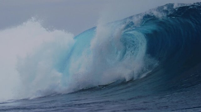 Slow motion sideview of surfer bailing off of board as it gets tossed over the falls at Cloudbreak Fiji