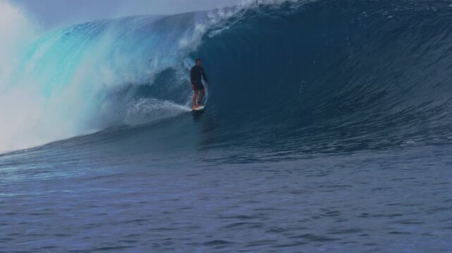 Surfer drops in and stands up calmly in slow motion at Cloudbreak Fiji