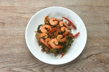spicy stir fried chop pork with chili and basil leaf topping shrimp on plate  