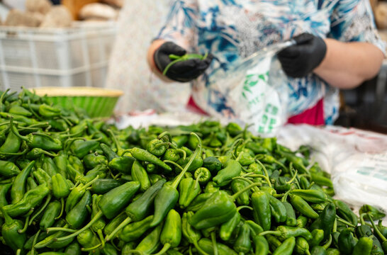 Gaician woman is selling green padron peppers selling at a fish market in Spain