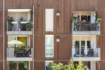 Wooden Facade of High rise Apartment Building with Modern Balcony and Large Windows in Munich Germany. Modern Exterior Design of Residential Building with Eco Facade. © Maryana