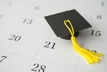 Graduation cap or mortarboard on white blank calendar background. University graduation ceremonies...