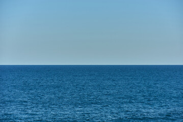 Calm Sea Horizon Background. Calm Blue Ocean Beach Water With Clear Blue Sky.