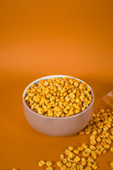 Corcflakes or Marning or marneng is traditional snack from indonesia. Made from corn kernels that fried. Fried corn in bowl with isolated background