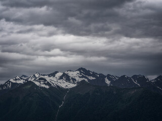 Obraz premium A majestic mountain landscape with snow-capped peaks reflecting the bright rays of the sun and creating an atmosphere of tranquility