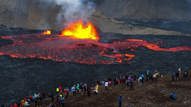 The eruption of Fagradalsfjall volcano in Iceland showcases a dramatic scene with flowing lava, fiery craters, and billowing smoke, highlighting the raw power of nature.