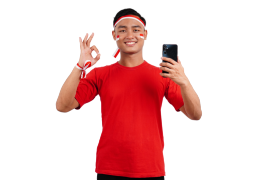 An Indonesian man celebrating Indonesia's independence day on 17 August while holding smartphone with blank screen isolated transparent