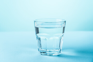 Glass of water on blue background.