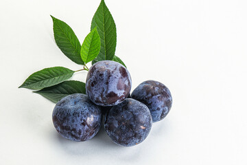 Raw purple plums heap with leaves