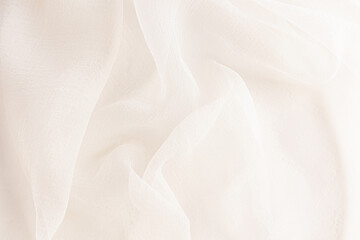 delicate soft folds of chiffon, silk, transparent fabric in champagne, ivory, beige as a wedding background with a copy space.