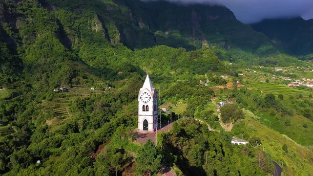 Chapel of Our Lady of Fatima (Capelinha de Nossa Senhora de Fatima) on Sunny Day. Green Valley and Mountains. Sao Vicente, Madeira, Portugal. Aerial Drone Shot. Moving Backwards and Upwards