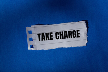 Take charge message written on ripped torn paper on blue background. Conceptual take charge symbol....