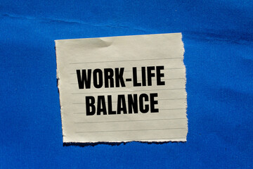 Work life balance message written on ripped torn paper piece on blue background. Conceptual work life balance symbol. Copy space.