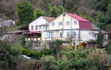 Residential buildings in a picturesque winter location on the slopes of green mountains.