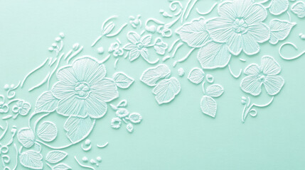 A mint abstract background featuring a delicate, embroidered pattern. The intricate details add a touch of elegance and tradition.