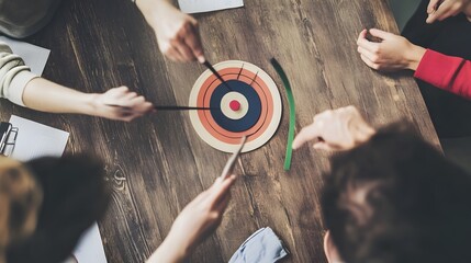 Four people play a game of skill and strategy using sticks and a target.