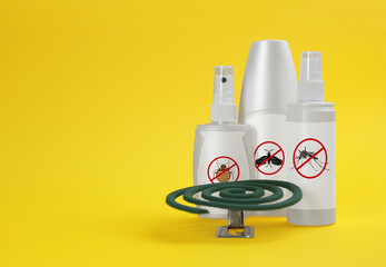 Mosquito coil and other insect repellents on yellow background, space for text