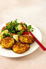 This savory breakfast features zucchini pancakes served with fresh lettuce and tomatoes, making for a wholesome and light meal that's both nutritious and satisfying