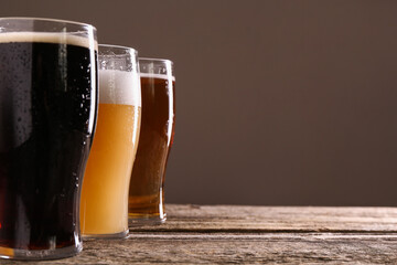Glasses with different types of beer on wooden table, closeup. Space for text
