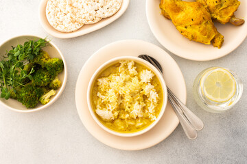 Stewed rabbit with rice, broccoli and rice cakes, served table with food