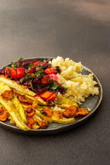 Enjoy a hearty breakfast or lunch with millet, baked zucchini, and carrots, paired with a fresh salad of seasonal vegetables and herbs, for a delicious vegetarian meal