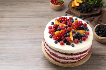 Tasty sponge cake with different fruits on wooden table, space for text