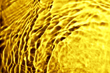 Gold fluid with ripples as background, closeup