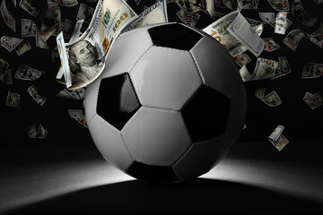Soccer ball under money rain on black background
