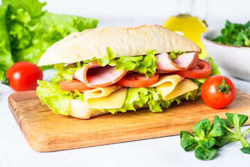 Sandwich with lettuce, cheese, tomatoes and ham. Healthy fast food snack. Isolated on white.