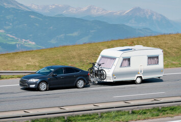 Fototapeta premium Family Car With RV Van And Bicycles in Mountainous Scenic Landscape
