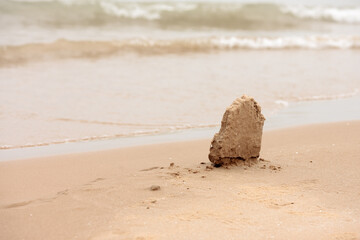 A small frozen clump of sand remains standing on the beach stand at Harrington Beach State Park, Belgium, Wisconsin, almost looking like a tombstone overlooking Lake Michigan