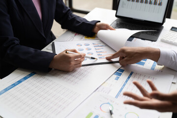 Businessman and woman discussing commercial real estate sector faces risks as financial buy used laptop calculator and chart in the office.