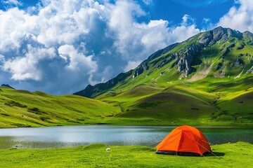 Majestic Mountain Landscape Featuring Orange Tent on Grassy Field Near Tranquil Lake Under Sunny Blue Sky