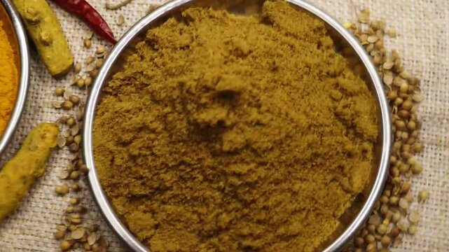 Spices background. Spice powder rotation periodically. Spinning of turmeric, red chili, cumin and coriander powder in bowl. Colorful spices. 