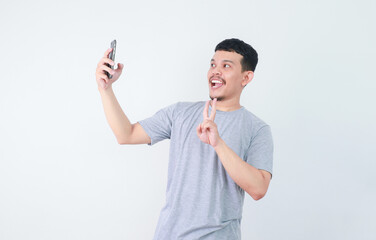 Adult Asian man taking a selfie photo with happy expression