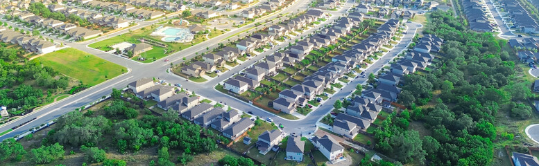 Panorama aerial urban sprawl suburban neighborhood subdivision long row of new development two story houses, community swimming pool, cul-de-sac keyhole shape dead-end street East of San Antonio