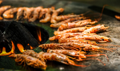 Cooking shrimp, octopus and sausage on a large grill