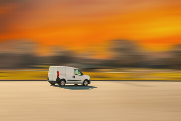White cargo van. Small light truck is driving on an asphalt street with a speed blur background. Cargo, goods delivery, courier services concept