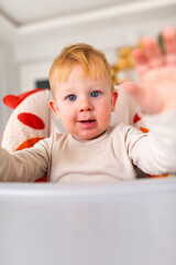 an emotional toddler sitting in a highchair.leery eye