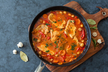 Fried pork loin in tomato sauce with mushrooms, red peppers and carrots